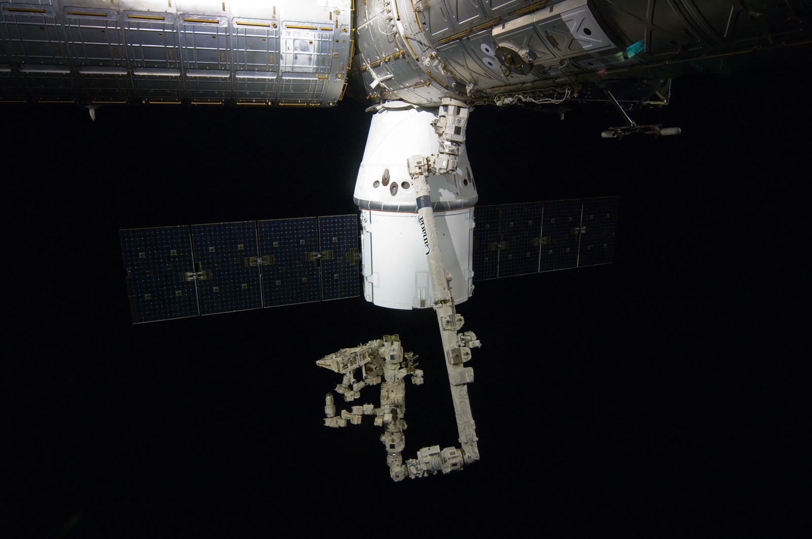 Dragon C2+ berthed to the Harmony module of the International Space Station with Earth below