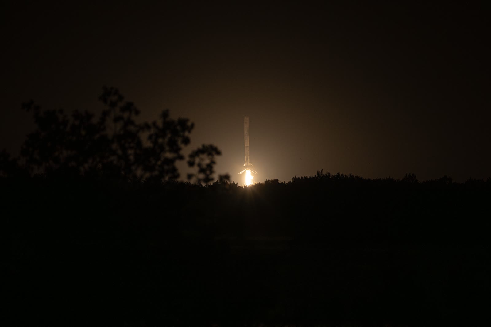 Falcon 9 first stage on its landing burn after launching NASA's Crew-12 mission